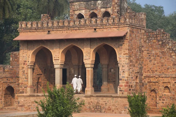 Homens vestidos brancos caminhando por Isa Khan Niyazi túmulo portão , — Fotografia de Stock