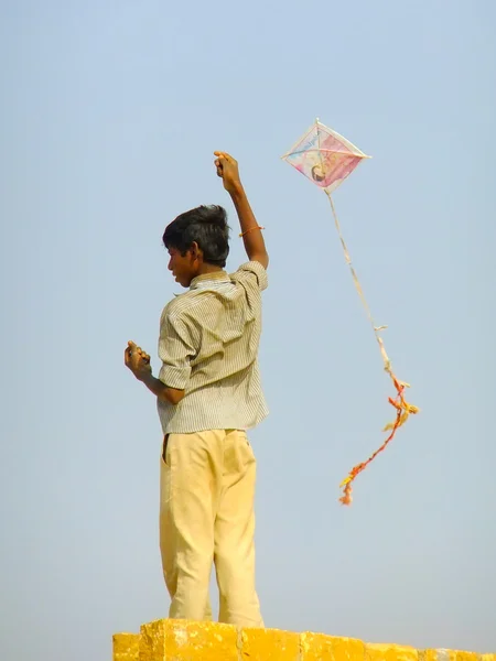 Niño indio volando cometa desde el techo de la casa tradicional en Tha —  Fotos de Stock