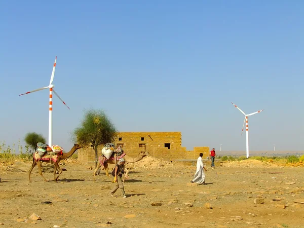 Mensen met kamelen gaan door kleine dorp in Thar woestijn in — Stockfoto