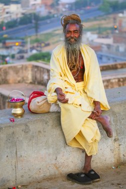 Jaipur, Hindistan - Kasım 14: Kimliği belirsiz adam Kasım'da Galta Tapınağı yakınlarındaki bir taş duvarda oturur 14, 2014 Jaipur, Hindistan. Jaipur, Hindistan'ın Rajasthan eyaletinin başkenti ve en büyük şehridir..