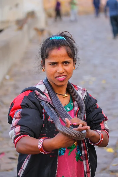 Джайпур, Индия - 14 ноября 2014 года неизвестная женщина стоит с коброй на улице в Джайпуре, Индия. Джайпур является столицей и крупнейшим городом индийского штата Раджастан . — стоковое фото