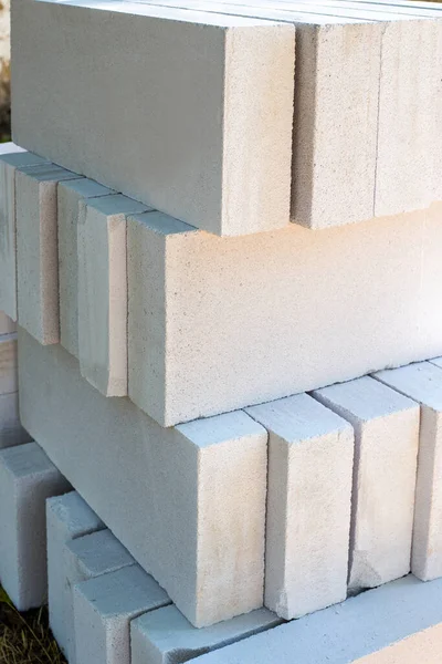 Blocchi di calcestruzzo aerato sono impilati uno sopra l'altro. Materiale da costruzione per edifici. Grandi mattoni bianchi — Foto Stock