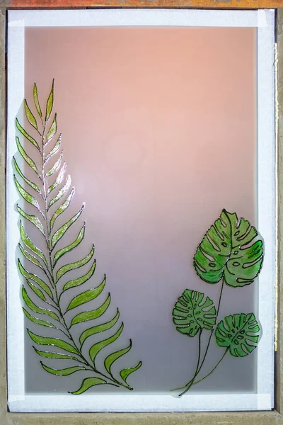 Installation and assembly of an interior frosted window with a stained-glass plant pattern.