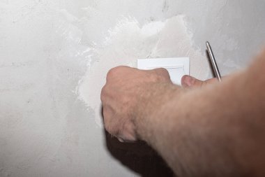 Prizi duvardan söküyorum. Elektrik kablolarının onarımı ve kurulumu.