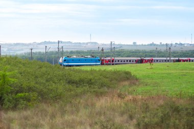 Anapa, Rusya - 09.26.2020: Bir Rus Demiryolları treni tarlalar ve çayırlar arasında raylarda ilerliyor