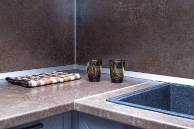Mutfak tezgahı ve önlüğü siyah taş bir lavabo ile kahverengi. Oda içi..