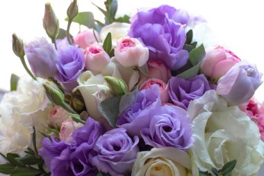 Beyaz arka planda çok renkli güllerden bir buket çiçek..