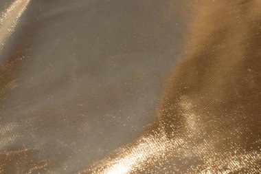 Kalın kumaşın altın arkaplanı. Yeni yıl metni için ışıltılı şablon