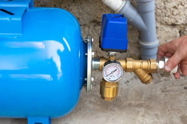 Installation of a water supply station to a residential building using a hydraulic accumulator. Pumping station. selective focus — Stock Image Installation Water Supply Station Residential Building Using Hydraulic Accumulator Pumping Stock Photo