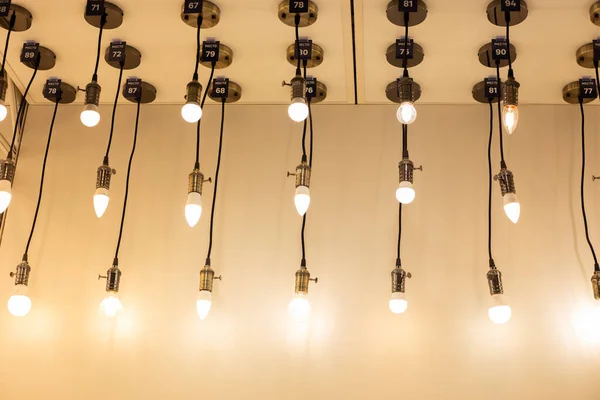 Decorative lamps hang from the ceiling against the backdrop of the wall, glowing with soft light. Designer room decoration