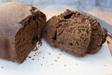 Ekmek makinesinde pişirilmiş dilimlenmiş taze kahverengi Borodino ekmeği. Aromatik ev yapımı kekler..