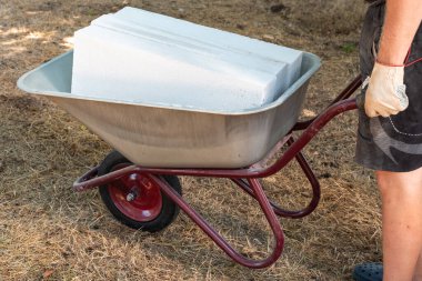 Bir adam tramvayda havalanmış beton blokları yuvarlıyor. Evlerin ve binaların inşaatı ve yeniden inşası. İstihdam.