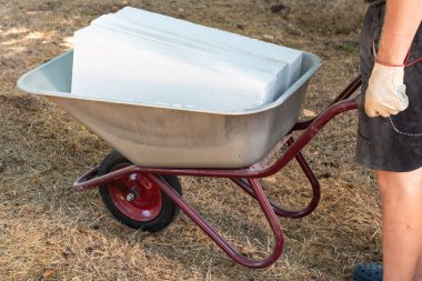 Bir adam tramvayda havalanmış beton blokları yuvarlıyor. Evlerin ve binaların inşası ve yeniden inşası