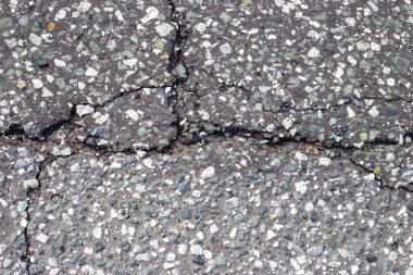 Çatlaklı gri asfalt, ince çakıllarla karışmış. Yol yüzey dokusu