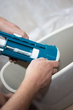 Tuvaleti kuruyorum. Bir işçi seramik bir tanka su pompası yerleştiriyor..