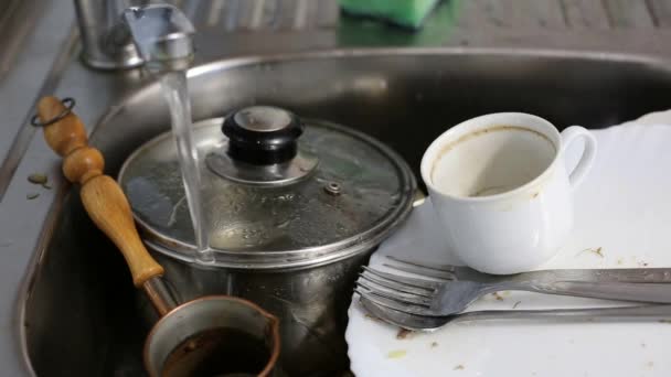 Tap water runs into the sink with dishes — Αρχείο Βίντεο