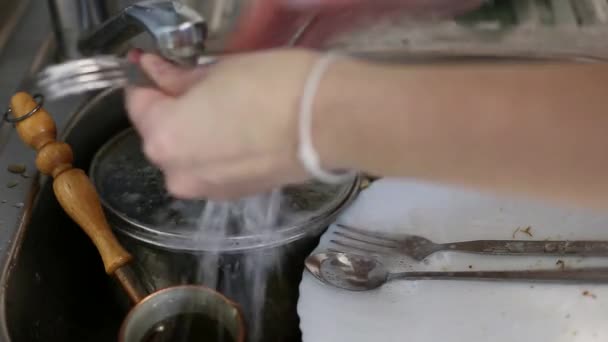 Жінка миє посуд під краном у раковині — стокове відео