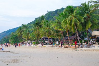Koh Chang, Tayland-01.2020: Turistlerin dinlendiği kumlu deniz kıyısı, tropik bölgelerde yaz tatili, beyaz kum plajı
