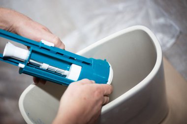 Tuvaleti kuruyorum. Bir işçi seramik bir tanka su pompası yerleştiriyor..