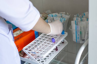 Khanty-Mansi Özerk Okrug, Rusya-09.06.2020: Hemşire kan testleri toplar. Cam bir masanın üzerinde kan testi tüpleri var. Coronavirüs araştırması.
