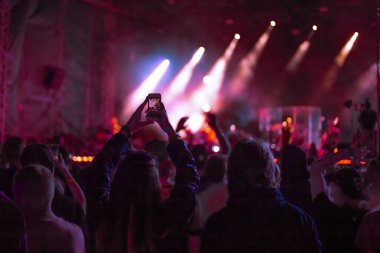 Bir müzik konseri dansında hayranlar ve telefonda video çekimi, açık hava gençlik festivali