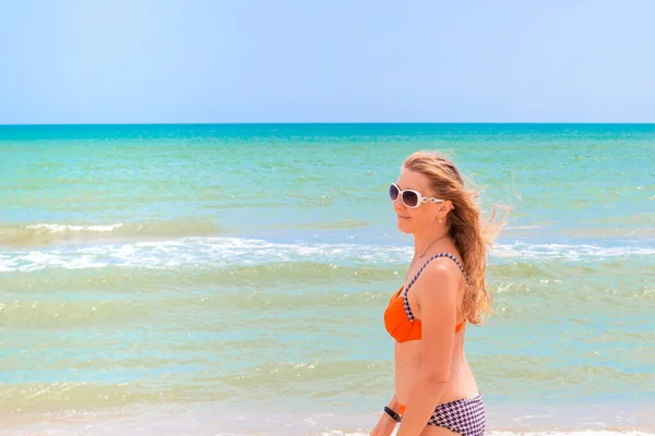 Dlouhosrstá Blondýna Slunečních Brýlích Plavkách Břehu Modrého Moře Usmívá Užívá — Stock fotografie