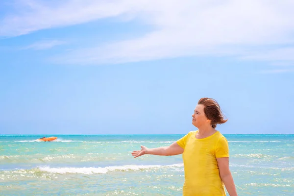 Starsza Kobieta Wybrzeżu Lazurowego Morza Przeciwko Błękitnemu Niebu Wyciągająca Rękę — Zdjęcie stockowe