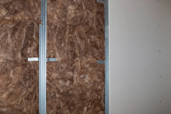 Insulation and sound insulation of walls with mineral wool, before facing with plasterboard. Home renovation,.