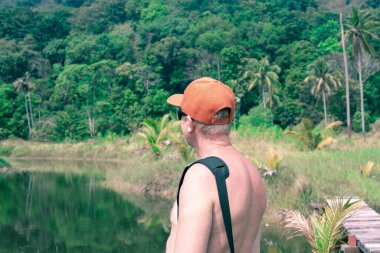 Tayland 'da tropikal bir ormanda çıplak gövdeli bir adam. Asya' da seyahat ve turizm.