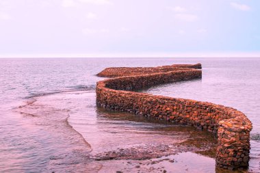 Sarma halindeki taş döşeme denize gidiyor, leylak rengi. Sakin deniz manzarası. Asya 'da dinlen..