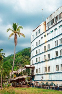 Koh Chang, Tayland-01.17.2020: Adada terk edilmiş bir otel - büyük, eski, paslı bir gemi, palmiye ağaçlarının arasında