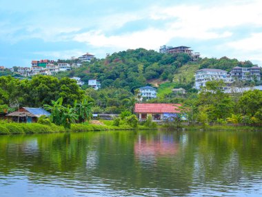 Asya 'da deniz kıyısı, yeşil tepe ve villalar, tropikal manzara