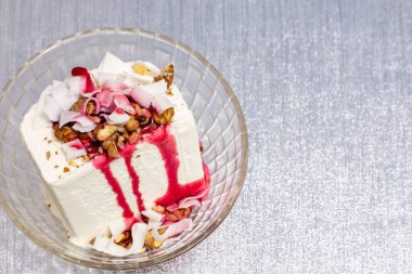 Fındıklı beyaz dondurma, hindistan cevizi ve gümüş bir yüzeyde üzerinde fotokopi alanı olan bir kâse.