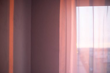 Duvardaki sabah güneşinin ışınları boş bir odada penceredeki beyaz tülden düşüyor. Yeni gün, atmosfer havası..