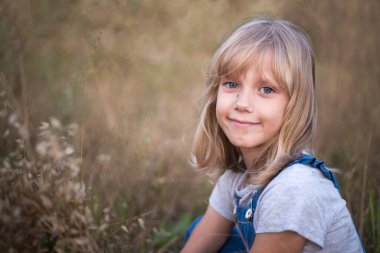 Yazın çayırda gülümseyen güzel sarışın kız. Kırsalda tasasız bir hafta sonu. Boşluğu kopyala.