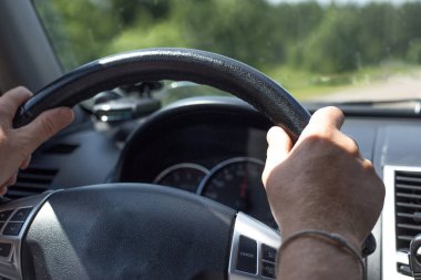 Yazın araba kullanırken direksiyonda bir adamın elleri.