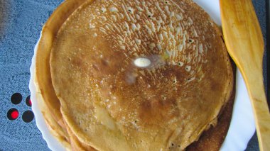 Rus gözlemeleri üst üste yığılmış, bir parça tereyağı eriyor. Bahar Festivali Maslenitsa.