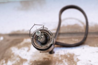 Yakın plan elektrik prizinde patlamış bir ampul. Elektrik kavramı, ışıklandırma sorunları.
