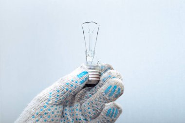 Ampulü değiştiriyorum. Eldivenli bir elektrikçi elinde patlamış bir ampul tutuyor..