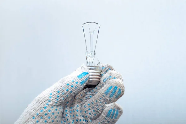 Ampulü değiştiriyorum. Eldivenli bir elektrikçi elinde patlamış bir ampul tutuyor..