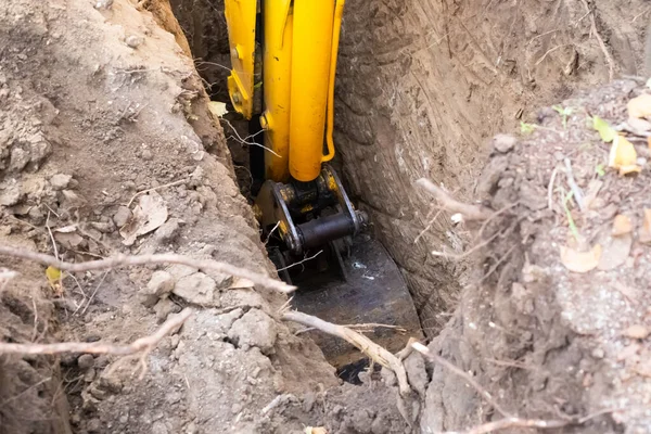 Kazıcı fosseptik tankının altındaki çukurdan kovayla toprağı temizliyor. Makineyi toprakla çalıştırmak.