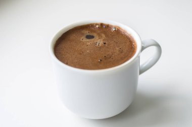 Hafif arka planda taze kahve demlenmiş beyaz kupa, yan görünüş, çalışma gününde günaydın.