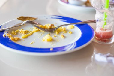 Yemekten sonra bir kafede çatal bıçak takımı ve kirli tabaklar.