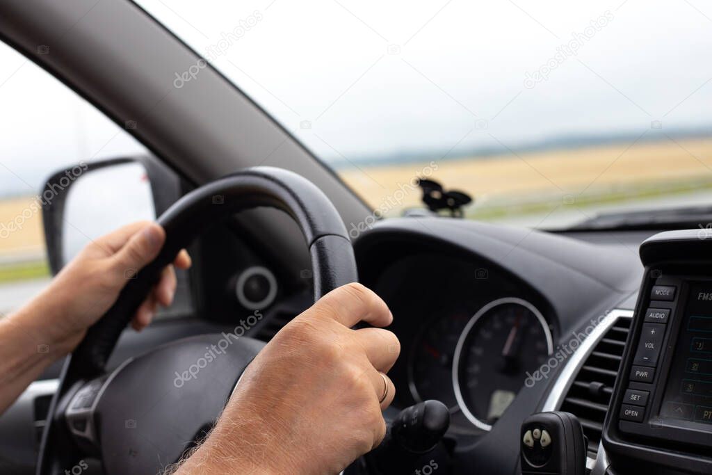 man's hands hold the steering wheel of a car, comfort and driving a car