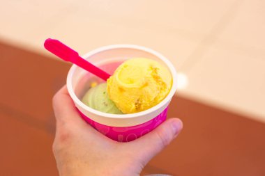 Kızın elinde çok renkli dondurma topları olan fincan, boşluğu kopyala