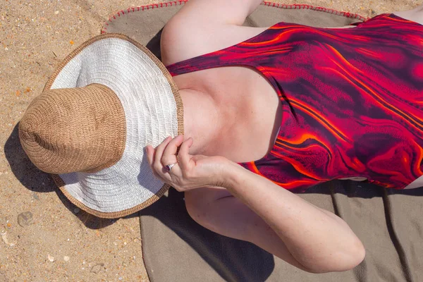 수영복을 할머니가 해변에 모자로 얼굴을 감싼다 — 스톡 사진