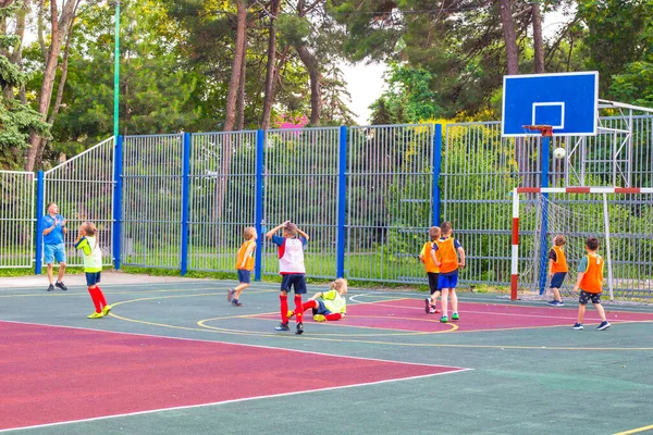 Anapa, Rusya-07.02.2021: Bir çocuk takımı spor sahasında futbol oynuyor. Top kapının üzerinde uçuyor.