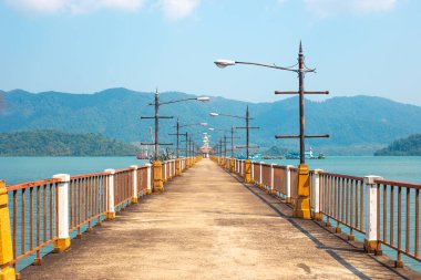 Asya 'daki dağların arka planına karşı denizde uzun bir iskele.