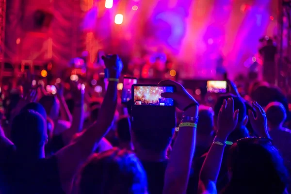 Um grupo de fãs levantou as mãos em um concerto de música — Fotografia de Stock