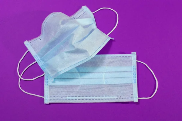 medical mask on a purple background, a means of hygiene and protection against viruses